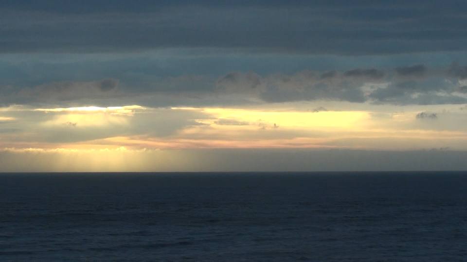 多い雲により様々な表情を見せる夕焼け空と日本海