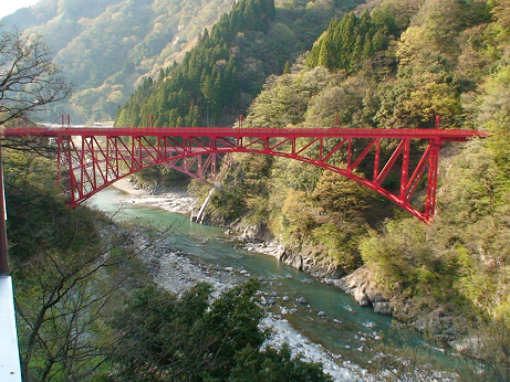 ホテル黒部からの景色：黒部峡谷鉄道の赤い鉄橋の下には川が流れる